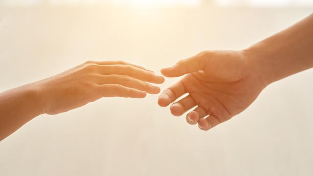 Hands of couple reaching for each other